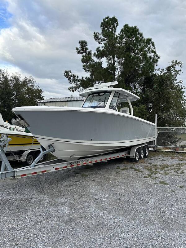 Gray center console boat on a triple-axle trailer in the shop yard