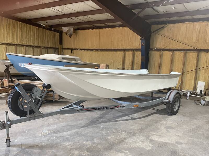 White skiff on a trailer inside the shop